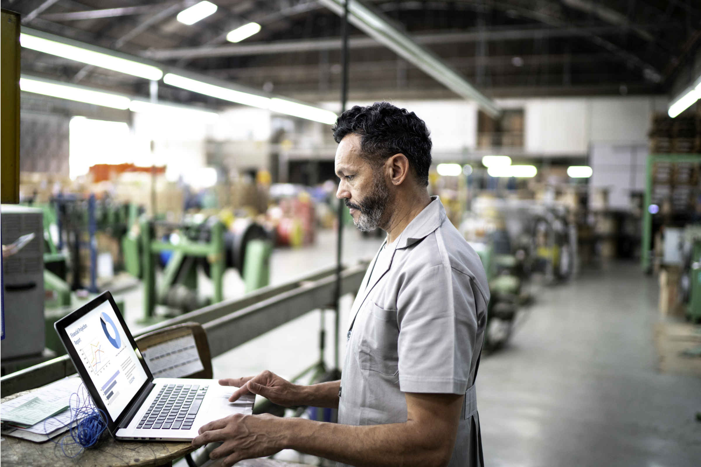 Technician using laptop while working in a factory